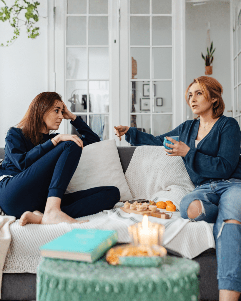 Two women conversing on a sofa