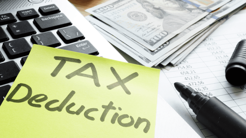 Tax deduction note on top of calculator with cash on a desk